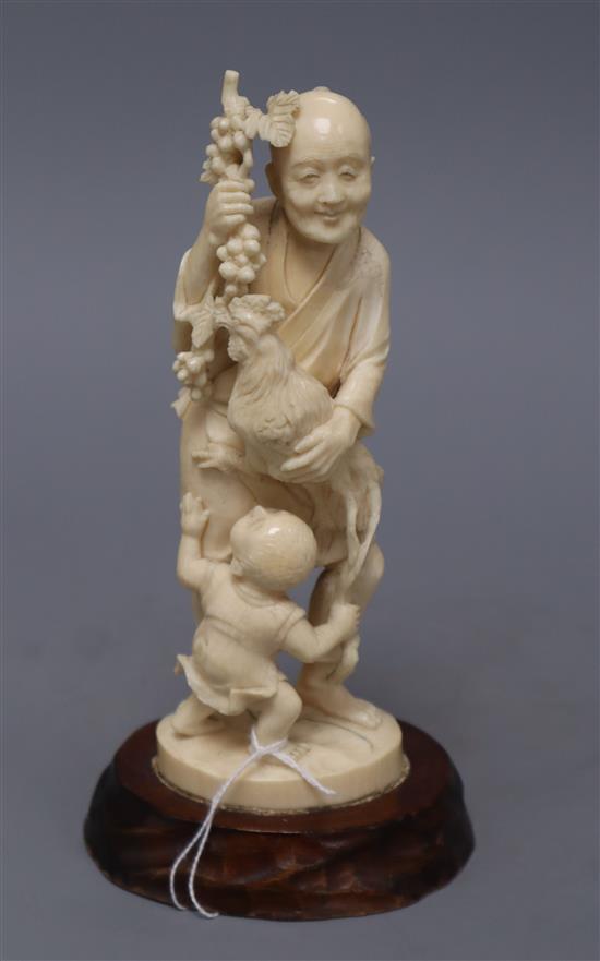 A Japanese ivory okimono group of a gentleman, a cockerel and a young boy, overall height 20cm